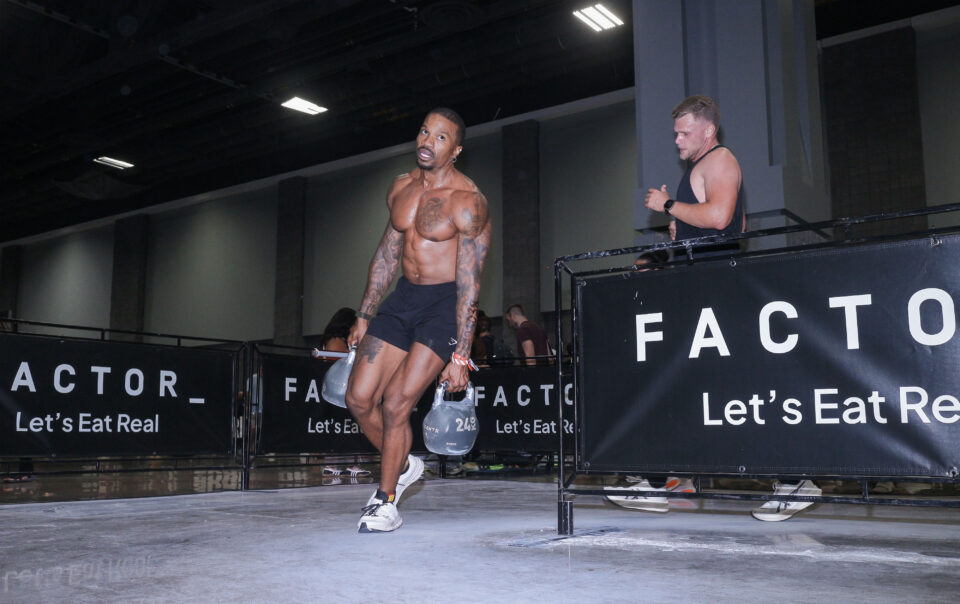 Brandon RaSean carrying two kettlebells during a HYROX doubles race in Washington, D.C.