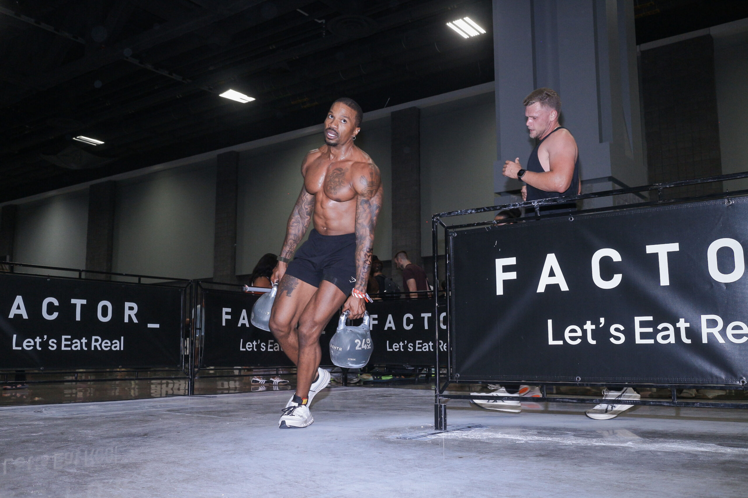 Brandon RaSean carrying two kettlebells during a HYROX doubles race in Washington, D.C.