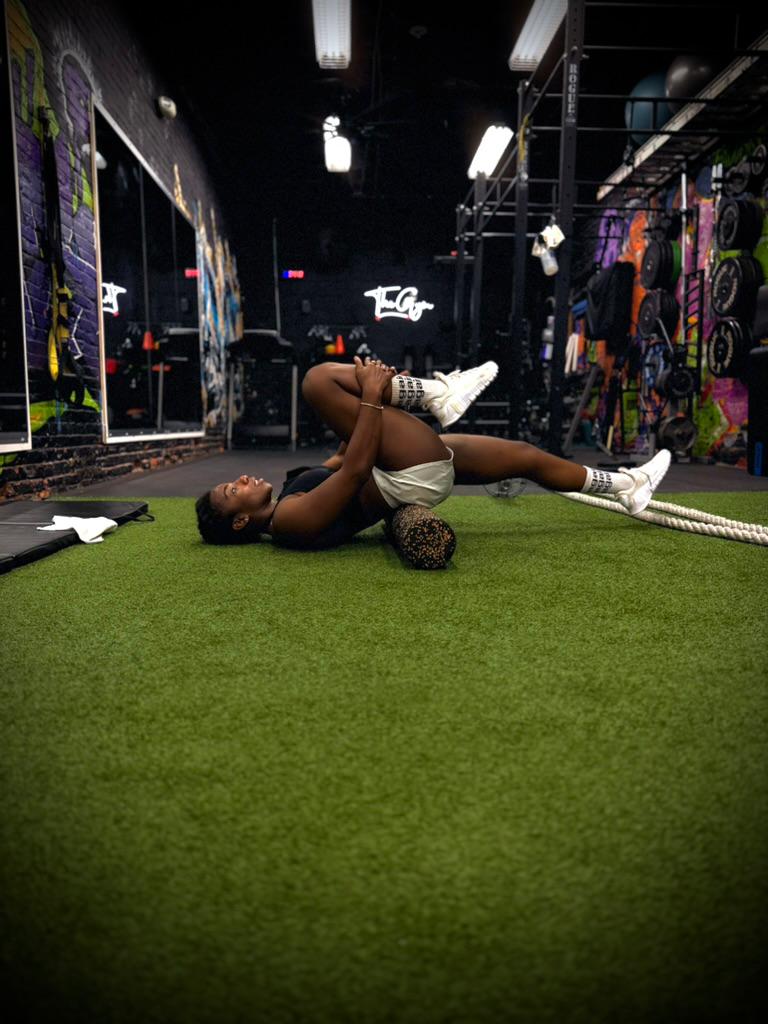 Client stretching on the gym turf